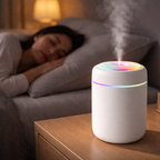 Woman sleeping in bed with a humidifier on a nightstand emitting steam.